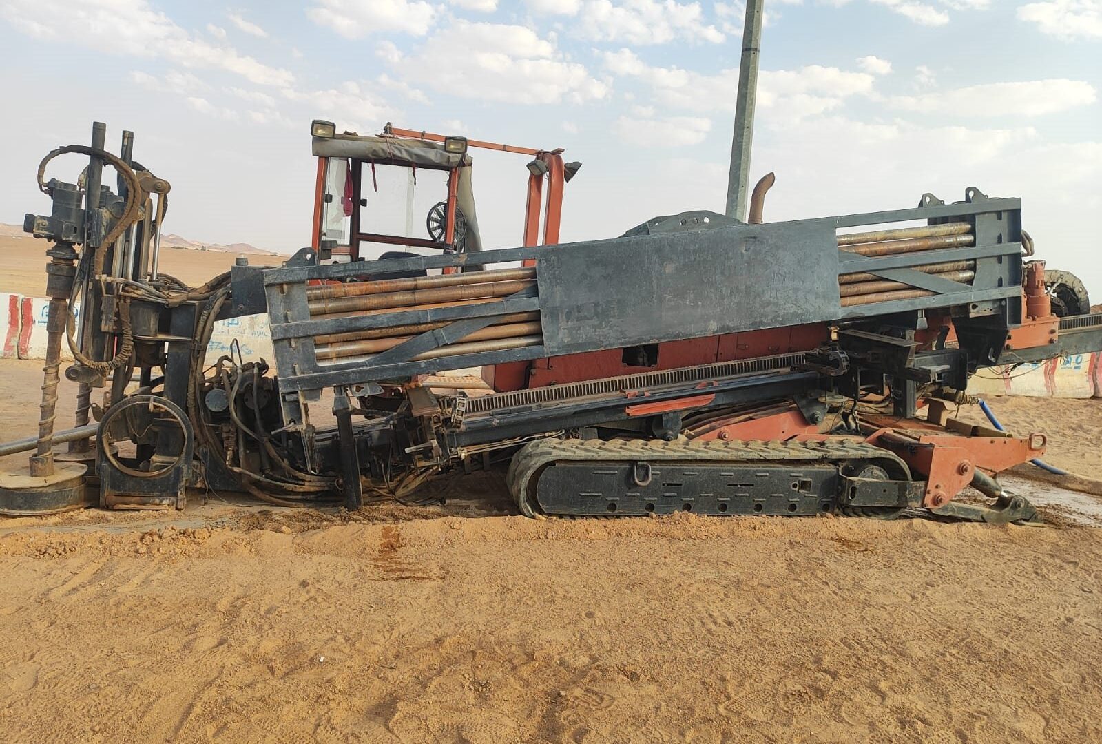 حفارة حفر أفقي موجّه برفّ قضبان الحفر في موقع رملي